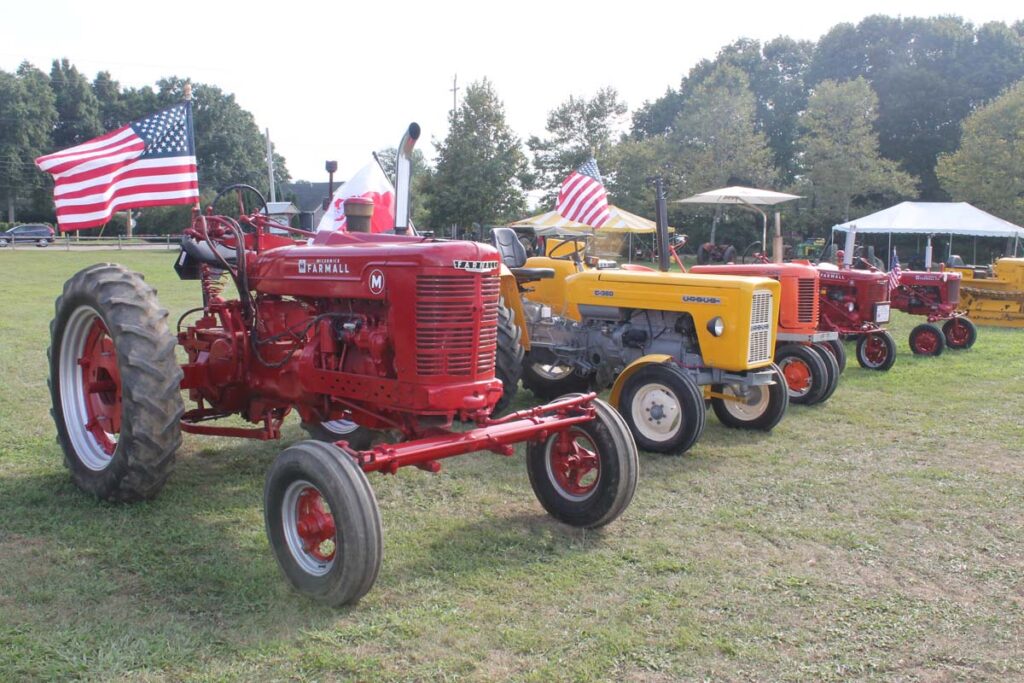 A group of tractors with American flags at the Hallockville Country Fair