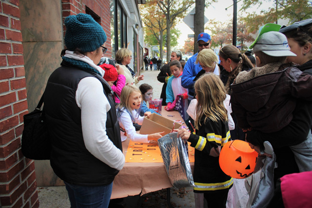 Local Girl Scout Troop 220 distributing Halloween candy to trick-or-treaters in front of the Riverhead Farmer’s Market.
