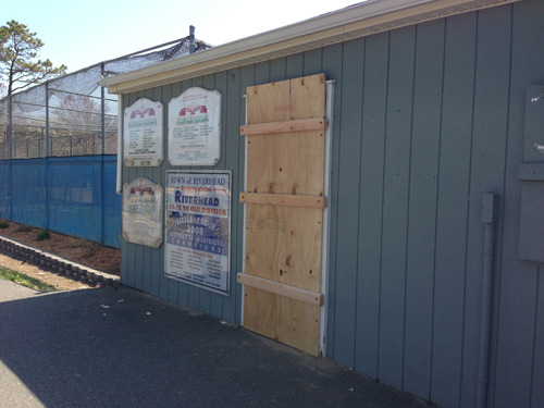 PAUL SQUIRE PHOTO | A Riverhead Town employee boarded up the Little League's storage area Sunday morning after someone broke into the building the night before. 