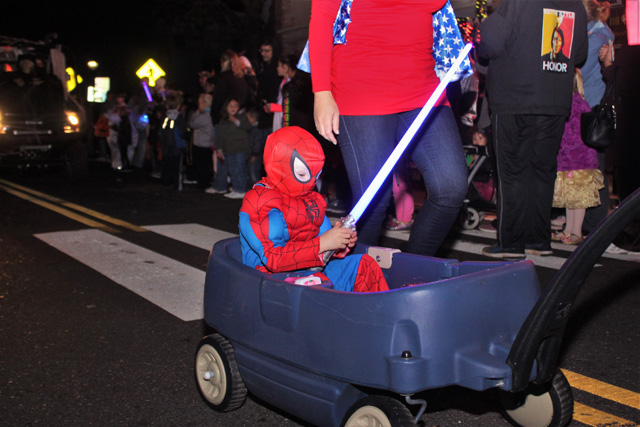 Spiderman with a light saber being towed in the wagon after a long day of trick-or-treating.