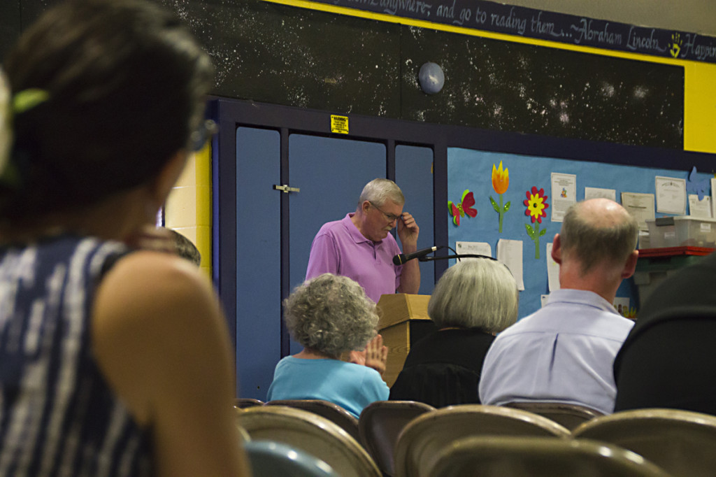 Resident Michael Burns (center) addresses the board last week as neighbors watch on. Mr. Burns was one of a handful to criticize a plan to build a new parking lot. (Credit: Paul Squire)
