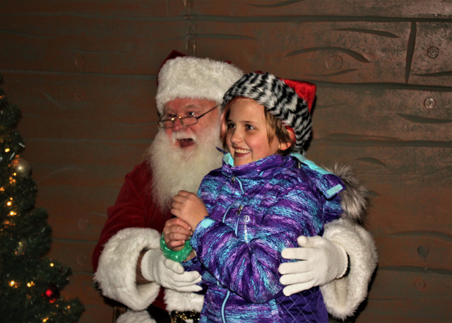 Santa and Natalie Tucci of Riverhead. Natalie tugged Santa’s beard to check if it was real. It is! (Credit: Elizabeth Wagner)