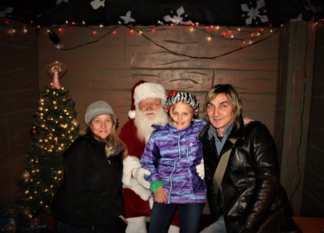 Event organizer and Executive Director of the Riverhead BID, Diane Tucci, posing for a photo with daughter Natalie Tucci, John Golden and Santa. (Credit: Elizabeth Wagner)
