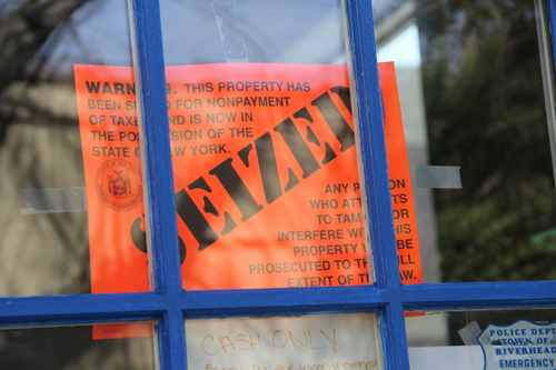 An orange sign on the locked door of Blue Agave Mexican Grill announcing that the restaurant was seized Tuesday afternoon. (Credit: Carrie Miller)