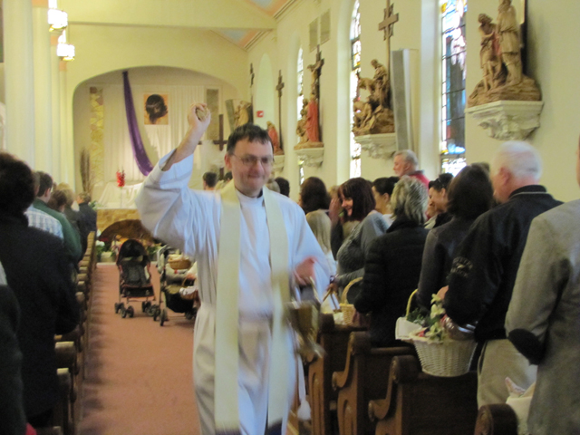 Father Piotr Narkiewicz of St. Isidore Church in Riverhead participates in the annual blessing of the food baskets Saturday morning, an Easter tradition in the Polish church. 