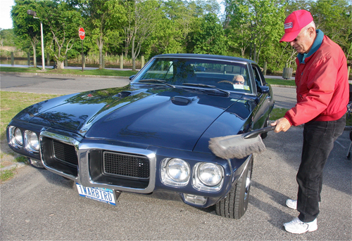 Bill Mango of Aquebogue cleans off his 1969 Pontiac Firebird as his girlfriend Marie Sigother sits in the driver's seat. He bought the car in 1974 and is the second owner. It has 90,000 miles on it. (Credit: Barbaraellen Koch)