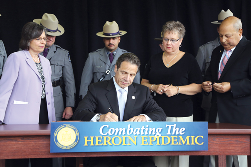 Gov. Andrew Cuomo signs legislation on Monday at the University of Binghampton related to tightening controls on heroin. (Credit: Office of Gov. 