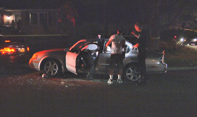 Investigators examine a vehicle at the scene of a shooting in Riverhead Saturday night. (Credit: Stringer News)