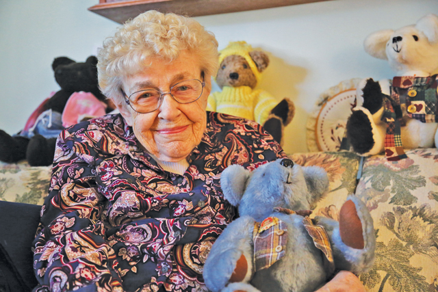 Emily Whitney, 92, sits with her blue stuffed teddy bear, the first stuffed animal she made. (Credit: Paul Squire)