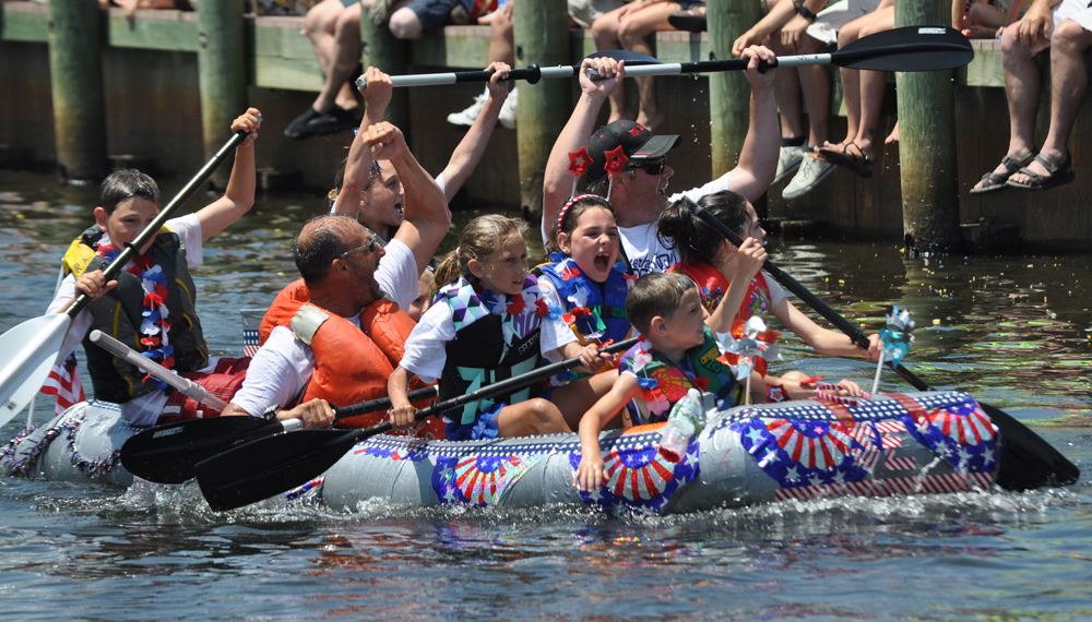 The crew of the Speedie Edie celebrates its victory down the home stretch of the team's heat of the Fifth Annual Cardboard Boat Race in downtown Riverhead Sunday. (Credit: Grant Parpan)