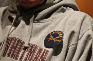 PAUL SQUIRE PHOTO | Students handed out buttons to help support their coach at the meeting.