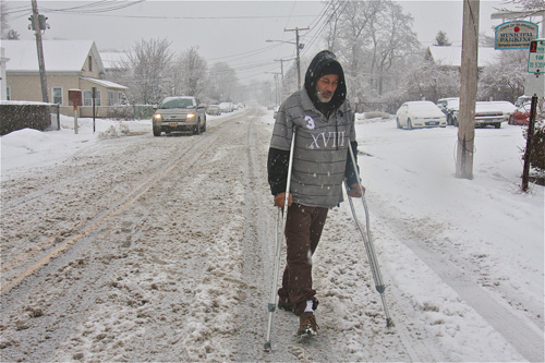 BARBARAELLEN KOCH PHOTO | Angel Almenis makes his way down Hamilton Avenue on crutches still recuperating from a broken ankle after he was hit by a car four months ago. He was headed to the Polish Town Corner Grocery and Deli to get coffee and breakfast. 