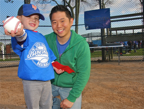 Jonas Wan, 4, at the opening ceremony for Riverhead Little League Friday evening, holding the ball and letter he donated to the league.