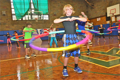 BARBARAELLEN KOCH PHOTO | Students participate in a Project Fit America exercise using weighted hula hoops.