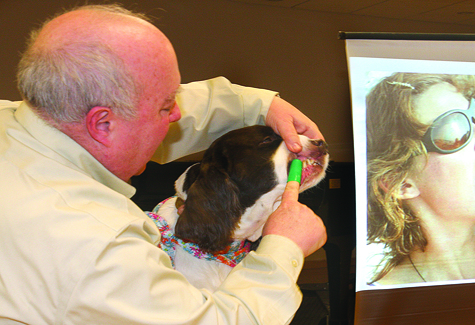 Kevin Dolan, a certified Pet Tech instructor from Huntington, gave a free seminar on dental care for cats and dogs at Riverhead Free Library Saturday afternoon. Here he demonstrates how to use a rubber finger brush on Holly, his 9-year-old English springer spaniel (who loves beef-flavored toothpaste).