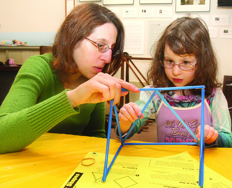 Jennifer Burzenski of Farmingdale helps her daughter Sarah, 5, create triangle and square shapes from straws and paper clips during Engineers Week at Long Island Science Center in Riverhead. They tested the shapes to see which made a more stable bridge.