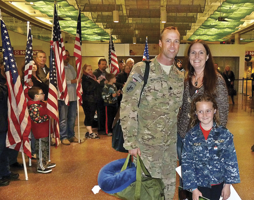 U.S. Navy Cmdr. Tim McAllister, his partner, Deanna Ziegler, and his 8-year-old daughter, Hollie, at his homecoming at MacArthur Airport Saturday night. (Credit: Courtesy photo)