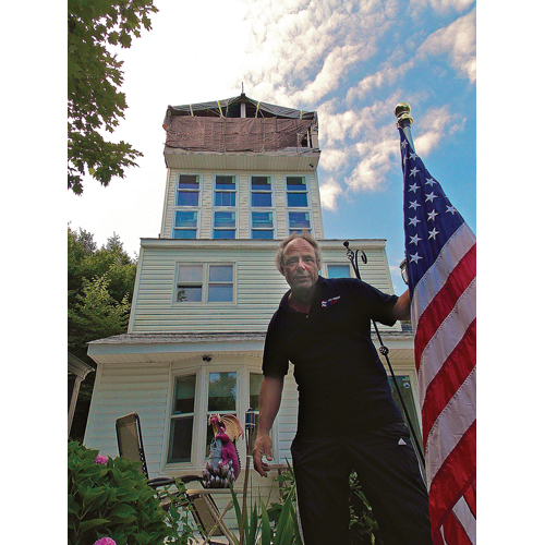 Eugene Lafurno pictured at his Baiting Hollow home, which he has dubbed 'The Epiphany.' Riverhead Town was given approval from a court last month to demolish the addition at the top of the house. (Credit: Joseph Pinciaro)