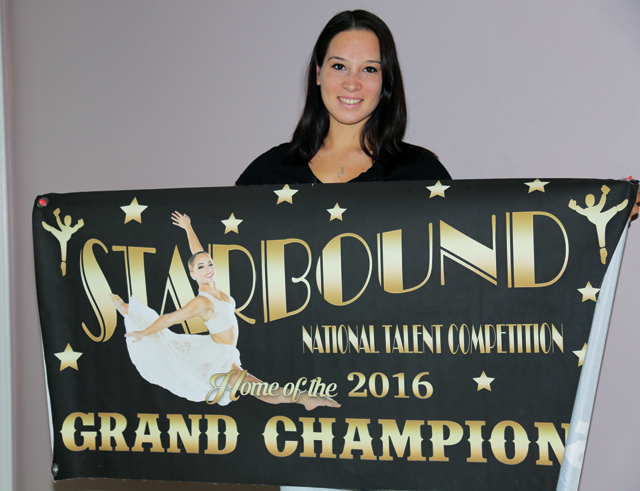 Ms. Latour poses with the grand champion banner at her home Friday. (Credit: Joe Werkmeister)