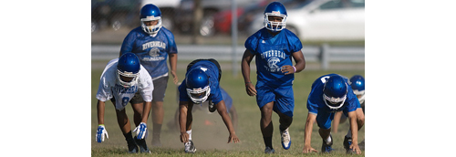 Riverhead players take part in a get-up drill during the team's first preseason practice on Monday morning. (Credit: Garret Meade)