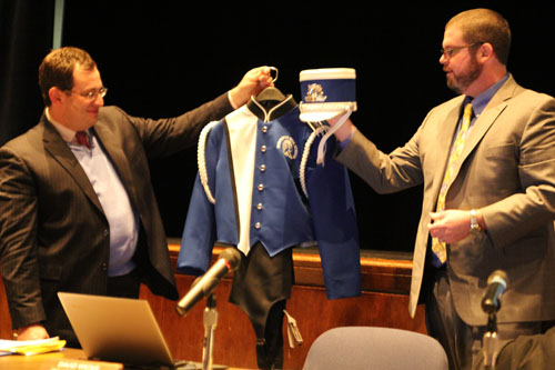 Assistant superintendents Sam Schneider, left, and David Wicks unveiling the new marching band uniforms. 