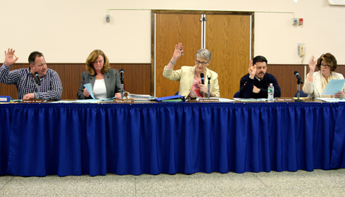 JENNIFER GUSTAVSON PHOTO | Riverhead school board members voting on resolutions Tuesday night. The board also adopted the 2013-14 budget.