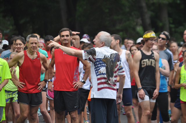 Coach Szymanski entertains the runners before the start of the 2015 SWR July 4 5K race. (Credit: Joe Werkmeister)