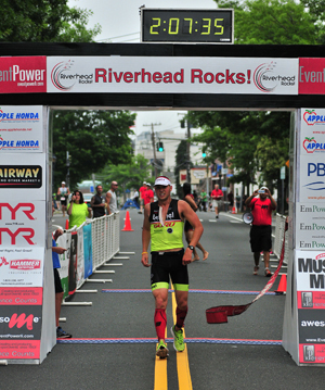 BILL LANDON PHOTO | Riverhead Rocks triathlon winner Tim Steiskal of Brookhaven as he crosses the finish line.