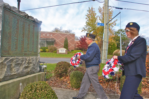 American Legion commander Mike Pankowski and Ladies Auxillary vice president Darlene Folkes place the wreaths at the War Memorial Monday morning.