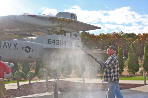 BARBARAELLEN KOCH PHOTO | Volunteer Paul Dooling, of Farmingdale, power washes the A-6E.