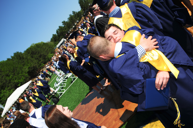Two graduates embrace. (Credit: Bill Landon)