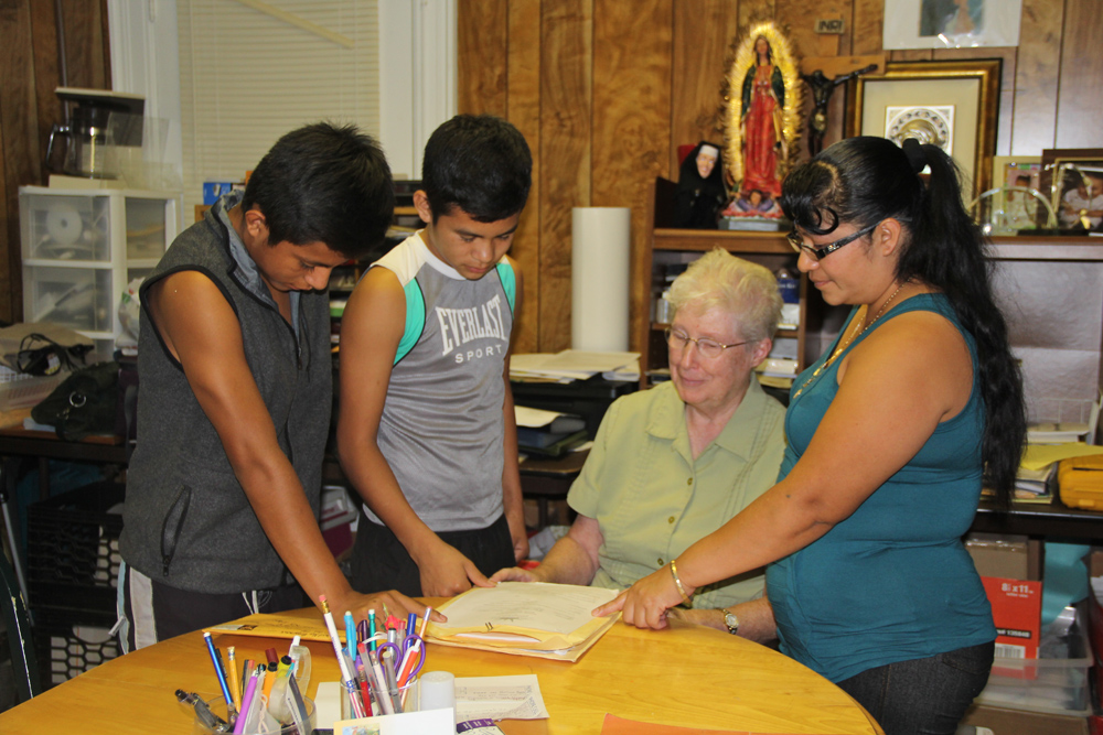 Sister Margaret Smyth of the North Fork Spanish Apostolate (center) with Estabon, 16, and Pedro, 14, and their mother Marta Tuesday afternoon. (Credit: Carrie Miller)