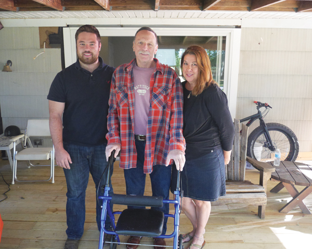 Bill (center) and Nancy Esposito with their son, Bill at home in Peconic. The family is on the back deck that was built for Mr. Esposito after he was injured in March (Credit: Krysten Massa)