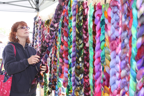 Linda Romar of Maryland looks at the Marino sheep rovings hand dyed by 'indy dyer fiber artist' Charisse DeCarlo of Lake Grove in 2012. (Credit: Barbaraellen Koch, file)