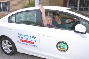 BARBARAELLEN KOCH PHOTO | Riverhead senior center aide Daryl Sulzer lets Etta Pietocha, 90, in the town's new natural gas vehicle after they just filled it up at National Grid property last year.