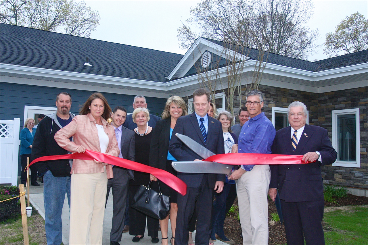 Brian Stark, president of Stark Homes, which operates Glenwood Village, cuts the ribbon with town officials outside the newly renovated and expanded "Clubhouse" Wednesday afternoon. (Credit: Barbaraellen Koch)