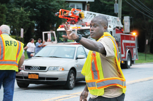 PAUL SQUIRE FILE PHOTO | Riverhead Fire Police Patrol 2nd Lt. Justin Winter, Jr. redirects traffic outside the scene of a kitchen fire this fall.