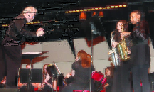 Riverhead High School band director Lee Hanwick conducts ninth-graders Jessica Sisti (left) and Kayla Myers in playing 'Baby, It's Cold Outside' during the school's March concert last Wednesday night. The orchestra and senior band also performed.