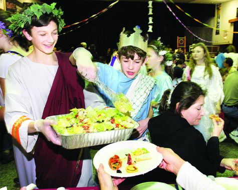 Riverhead Middle School seventh-graders Peter Cook (left) and Alex Bowe dish out salad at the schoolâs annual Roman banquet and play Thursday night. The banquet, held annually since 1997, featured various dishes prepared by parents and families of the middle school Latinists; the play written by students Bella Marcucci, Amy Methven and Liana Salgado.