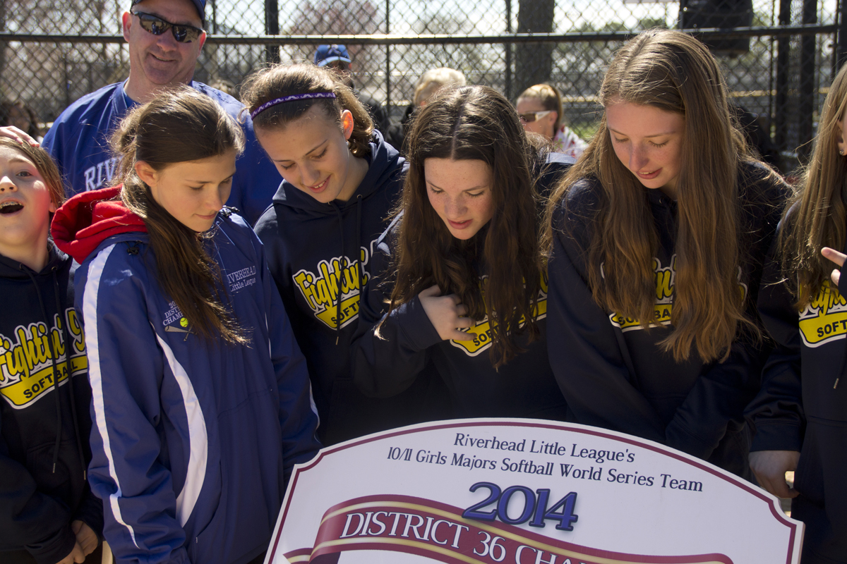 Members of last year's district winning softball team check for their names on the honorary plaque. (Credit: Paul Squire)