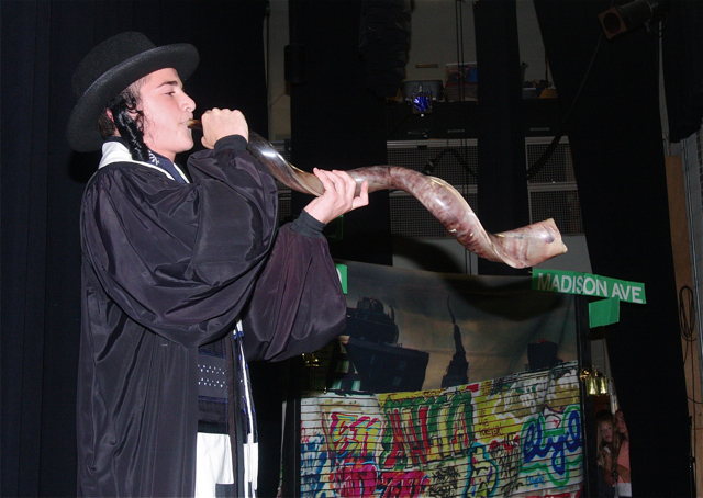Rabbi Matthew Menis beckons the audience with the shofar.
