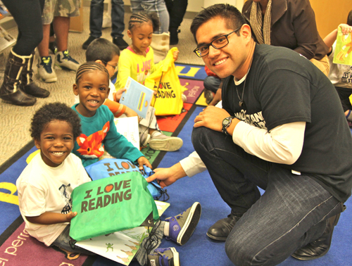 Head Start teacher Kevin Rojas helps distribute books to students at Riverhead Free Library on Thursday. (Credit: Jen Nuzzo photos)