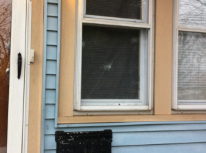 CARRIE MILLER PHOTO  |  Bullet holes in the window of an East Avenue home Tuesday morning. 
