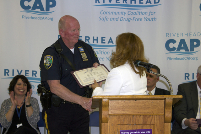 Riverhead Town Police Officer Dennis Cavanagh accepts a certificate on Monday honoring the police department for their efforts in preventing underage substance abuse. (Credit: Nicole Smith)