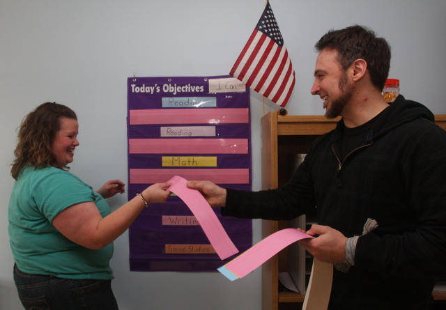 Integrated first grade co-teachers Lindsay Davis and Anthony Dohrenwend set up a teaching objectives display in their classroom Monday afternoon. (Credit: Barbaraellen Koch)