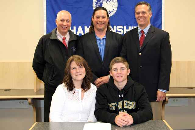Riverhead senior Cody Weiss will play golf at SUNY/Oswego. He was joined for a ceremony by his mother Doreen and athletic director Bill Groth (standing, left), golf coach Steve Failla and high school principal Charles Regan. (Credit: Riverhead School District)