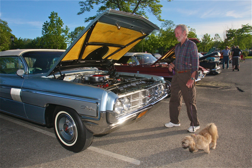 Gene Comer of Riverhead with his dog Miley checks out a 1960's Oldsmobile Starfire convertible. (Credit: Barbaraellen Koch)