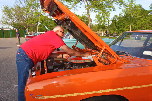 Dan Russo of Mattituck cleans off the air filter of his1970 Plymouth Roadrunner. It has a 440 cubic inch engine giving 400 horsepower. (Credit: Barbaraellen Koch)