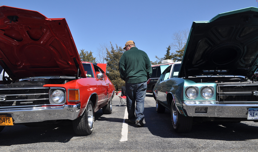 An attendee walks between two Chevys owned by Tobie Wesnofske of Cutchogue. (Credit: Vera Chinese)