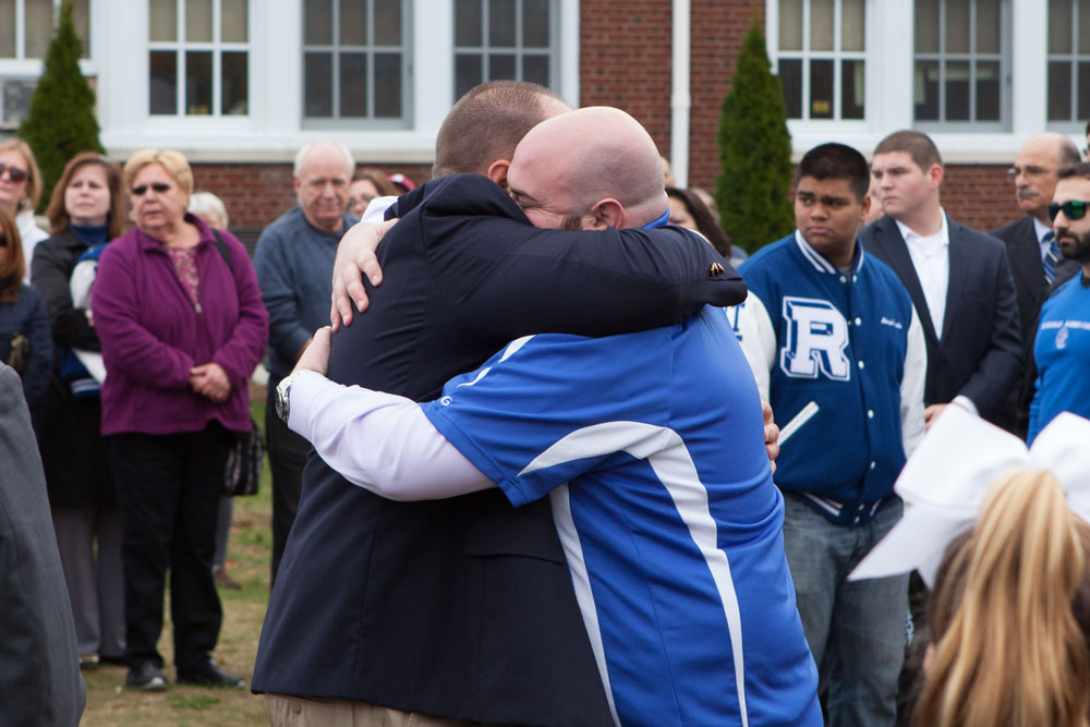 Riverhead football coach Leif Shay hugged each of the DeCabria brothers after they rang the bell. (Credit: Katharine Schroeder)